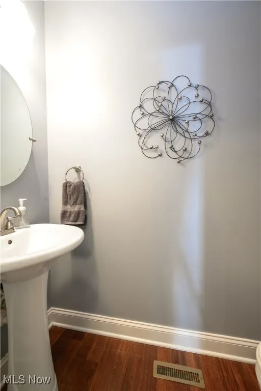 First floor half bath with hardwood flooring.
