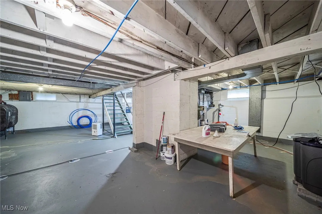 Basement featuring oil tank and stairs
