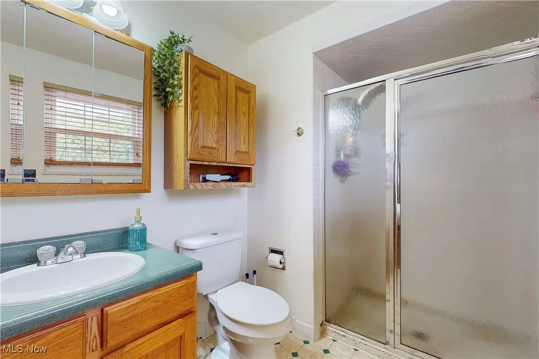 Bathroom with a stall shower, vanity, and light tile patterned floors