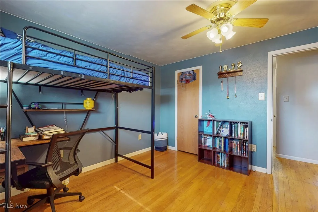 Bedroom with wood-type flooring, a desk, and a ceiling fan