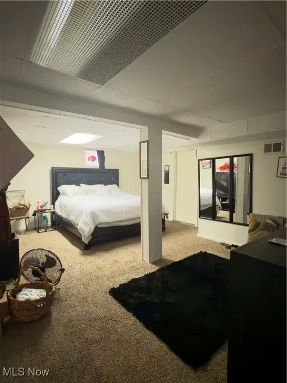 Carpeted bedroom featuring a drop ceiling