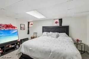 Carpeted bedroom with a paneled ceiling