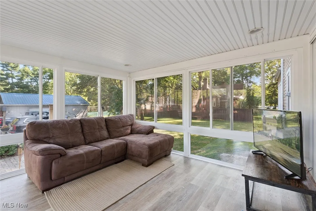 Sunroom / solarium with wood finished floors and outdoor lounge area