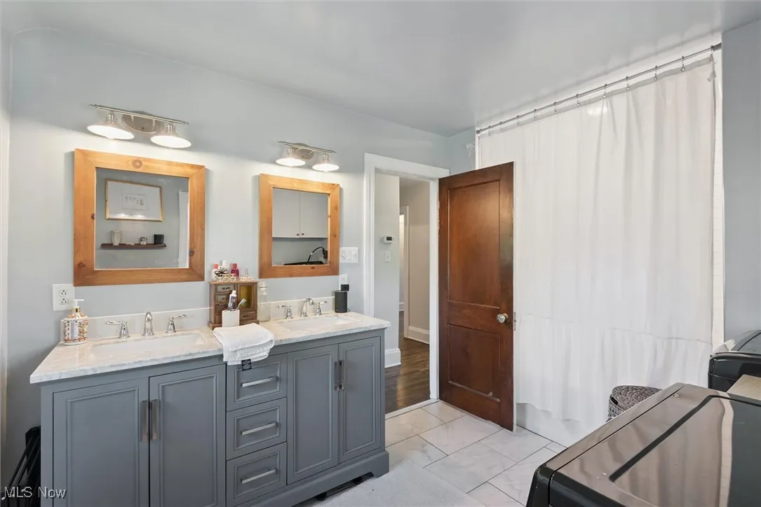 Full bath featuring double vanity and shower / bath combo