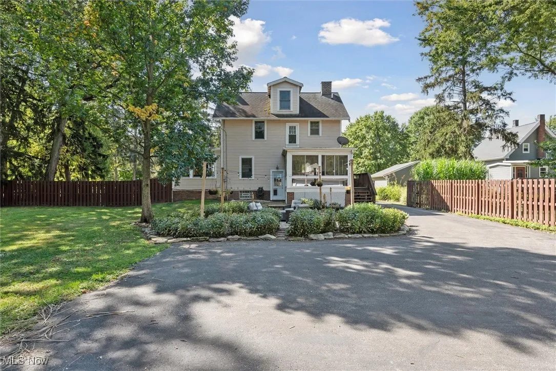 Rear view of property with a sunroom and a chimney