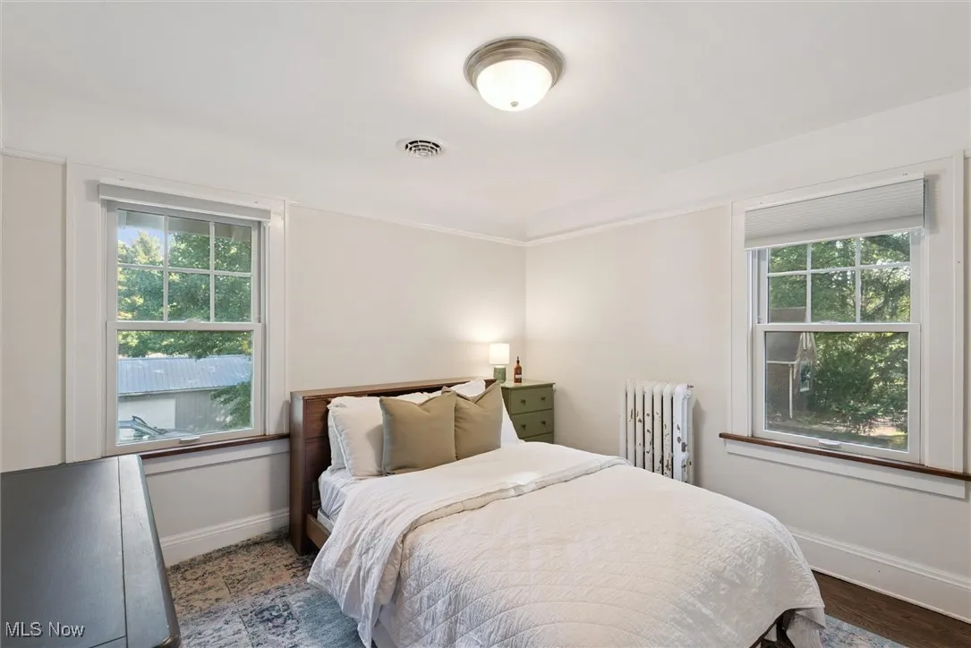 Bedroom with radiator and dark wood-type flooring