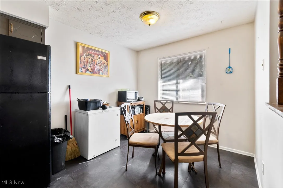 Dining room featuring a textured ceiling and baseboards