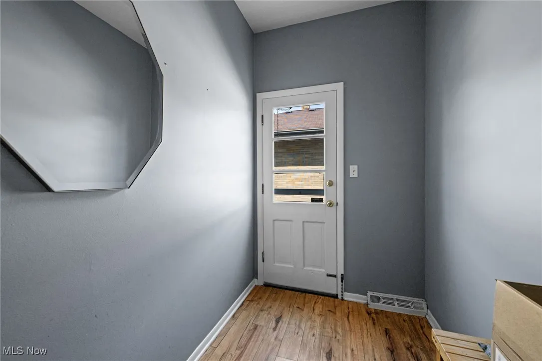 Doorway to outside with hardwood / wood-style flooring and baseboards
