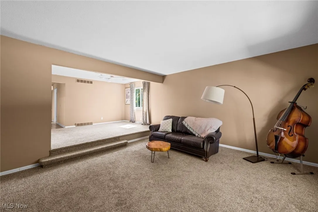 Carpeted living room featuring baseboards