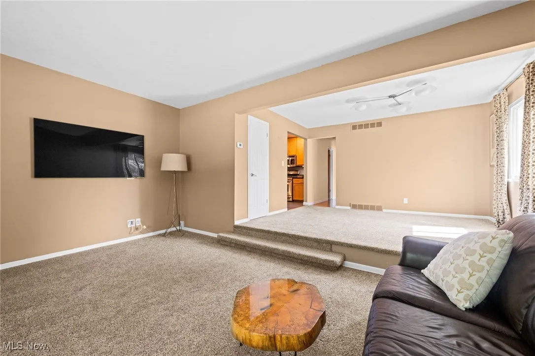 Carpeted living area with baseboards