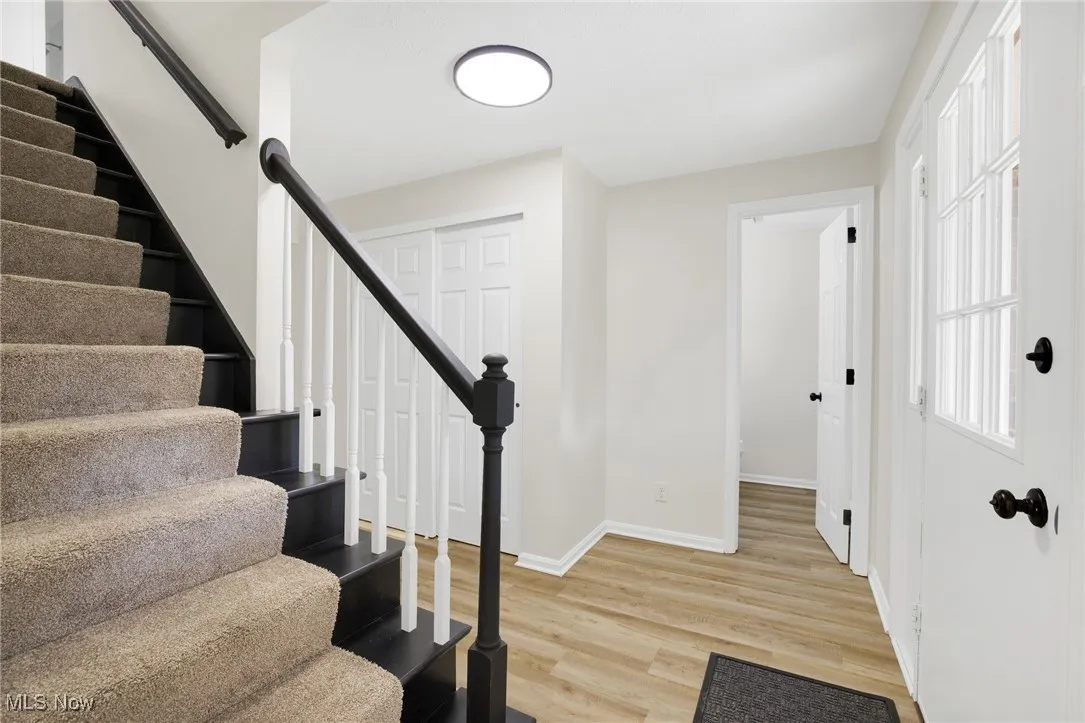 Stairs with wood finished floors and baseboards