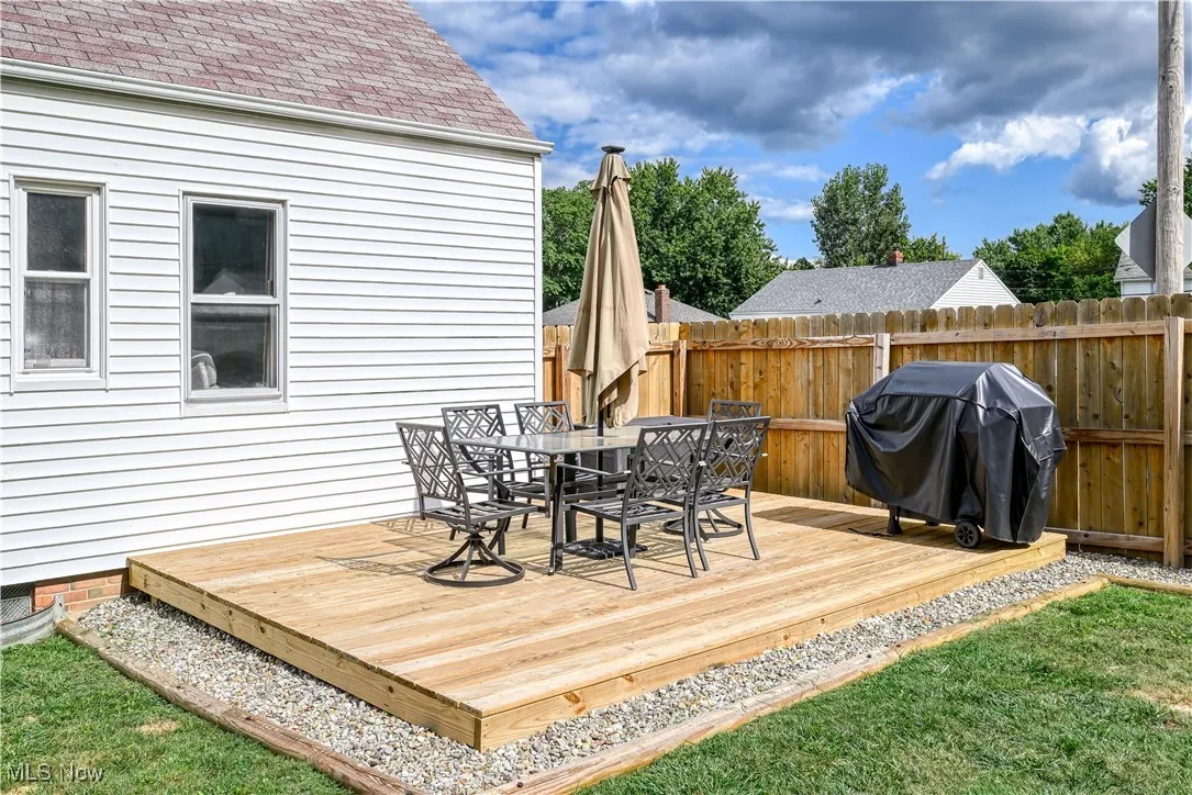 Wooden terrace featuring outdoor dining area and grilling area