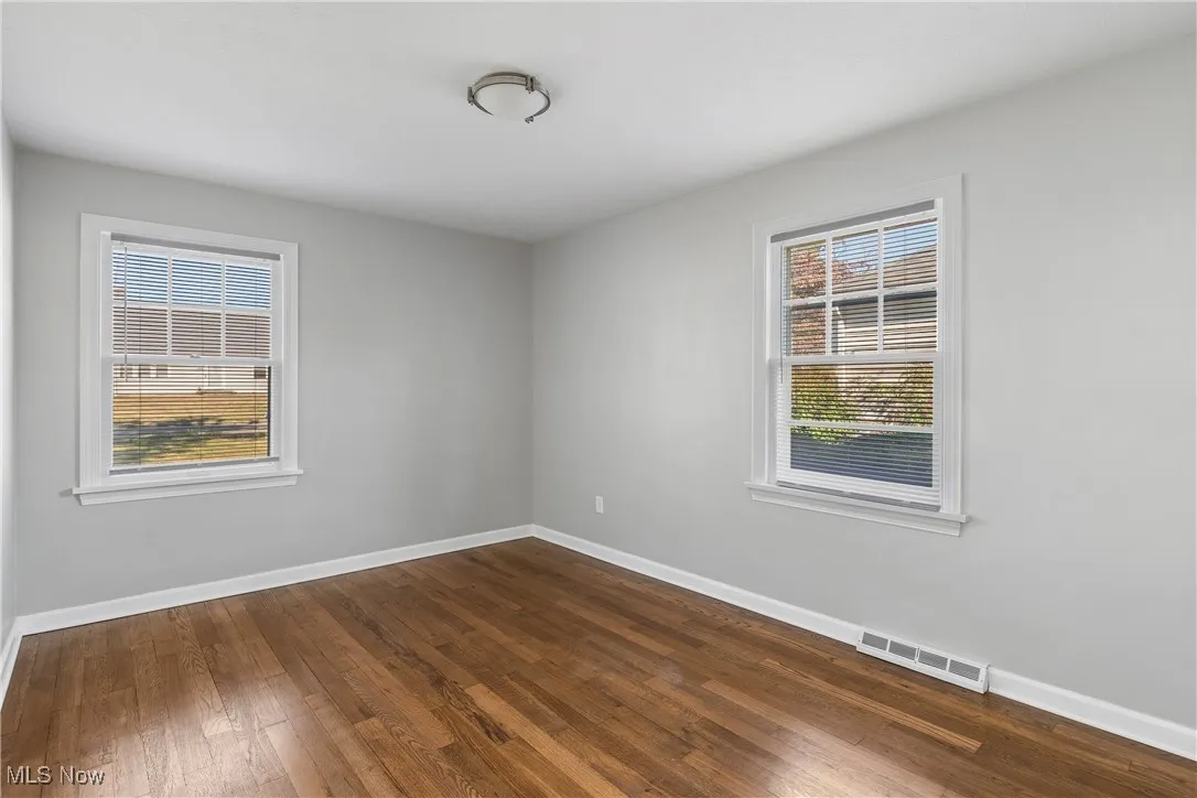 Empty room with baseboards and dark wood finished floors