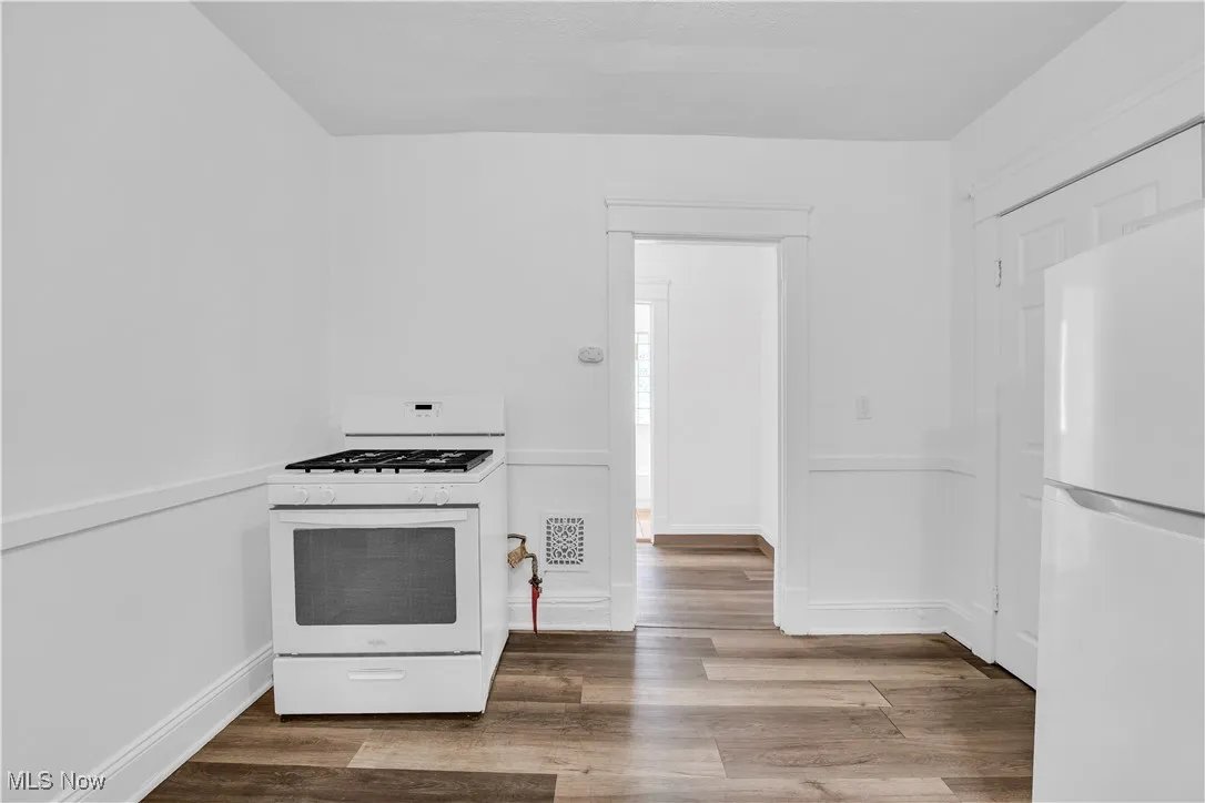 Kitchen featuring white appliances and wood finished floors