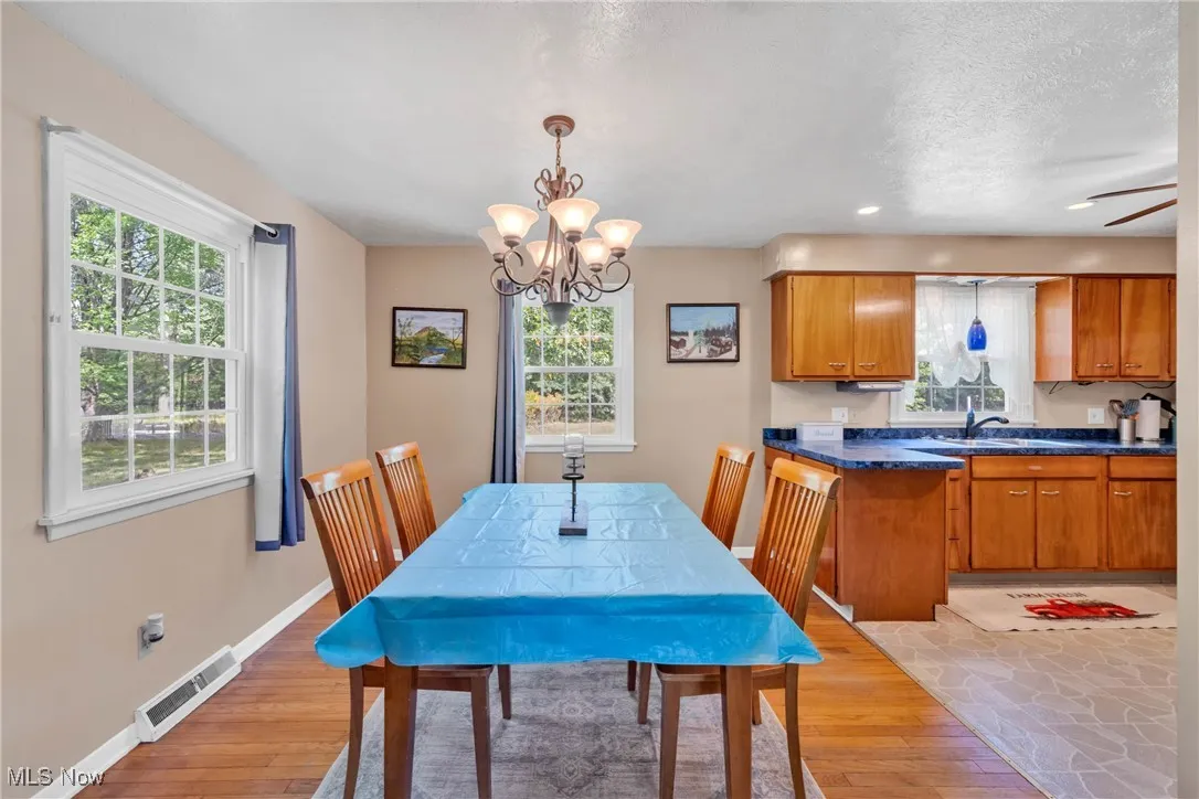 Dining area featuring hardwood floors, a chandelier, and a textured ceiling