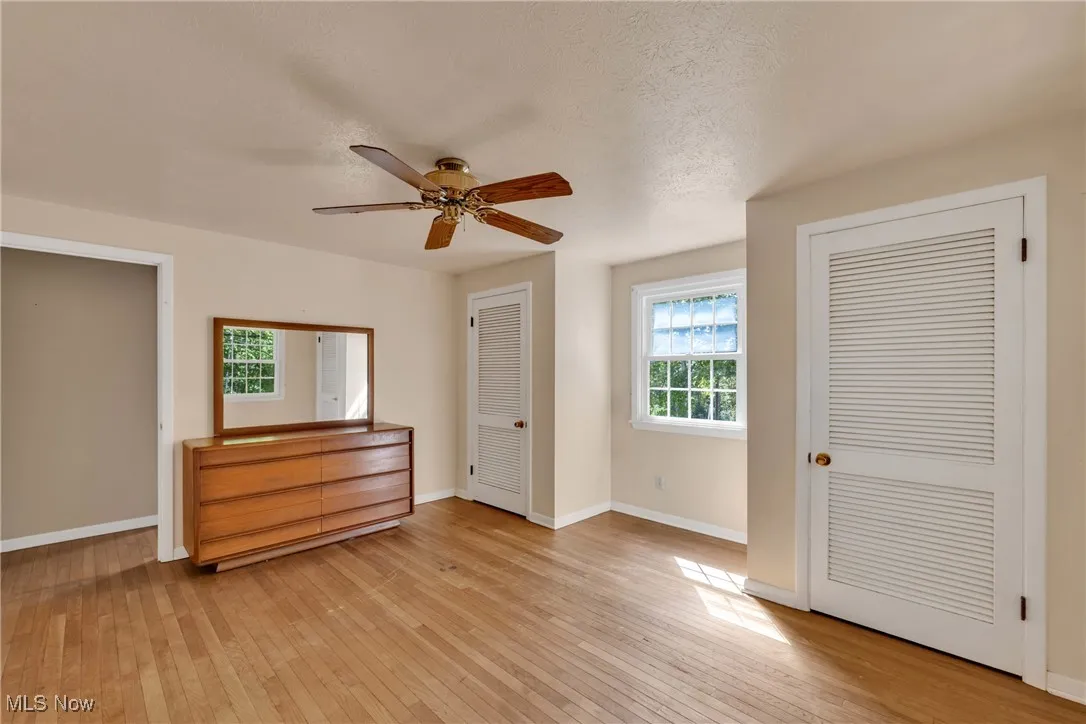 Bedroom with ceiling fan and alcove for your desk, hardwood floors