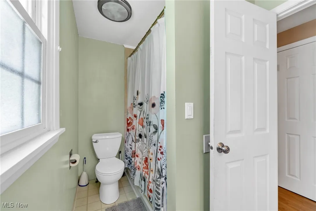 Bathroom featuring curtained shower with jetted tub and light tile patterned floors