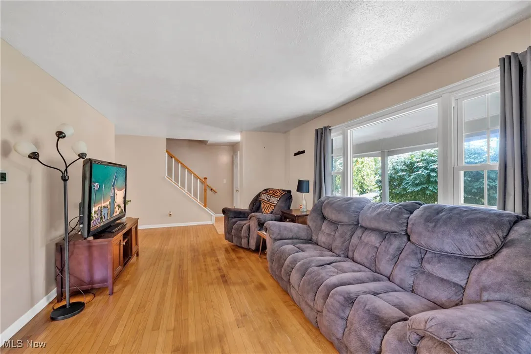 Living room featuring hardwood floors and stairs to the second floor