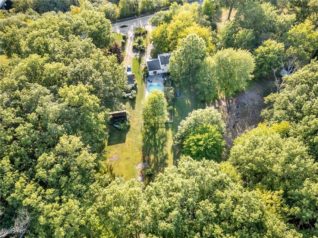 Aerial view of property and surrounding area featuring a heavily wooded area
