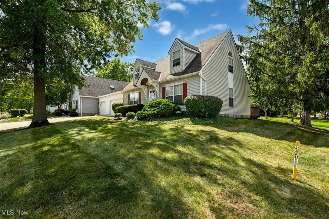 New england style home featuring a front yard and an attached garage
