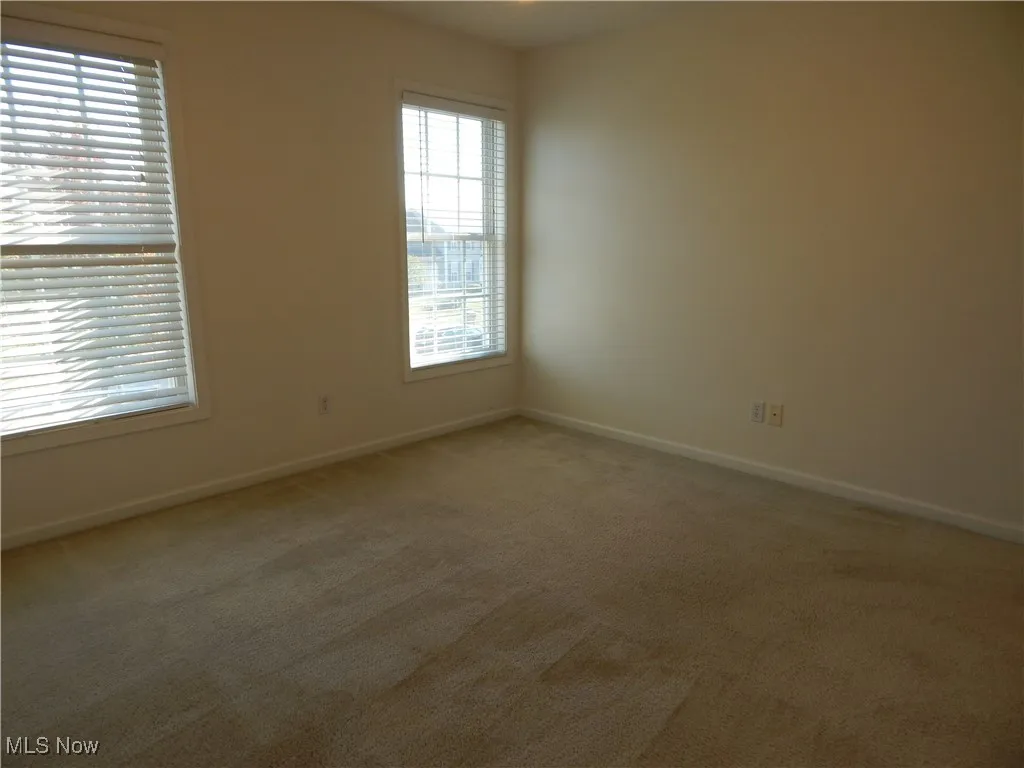 Carpeted empty room featuring baseboards