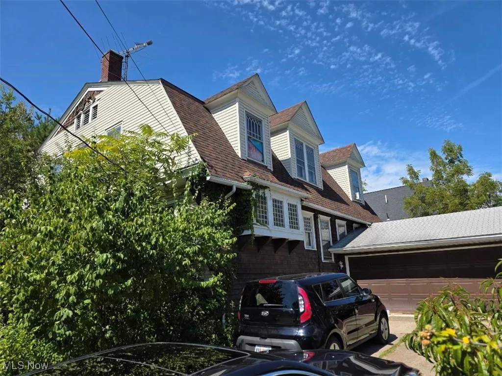 View of front of home with a garage, a shingled roof, and a​​‌​​​​‌​​‌‌​‌‌​​​‌‌​‌​‌​‌​​​‌​​ chimney