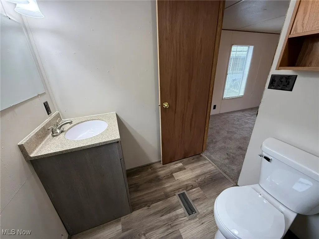 Half bath with vanity and wood finished floors