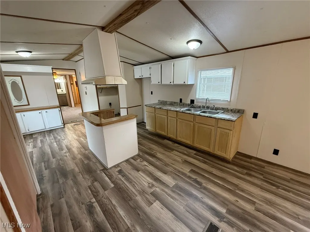 Kitchen with dark wood finished floors, white cabinets, and light countertops