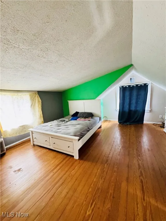 Bedroom featuring hardwood / wood-style floors and a textured ceiling