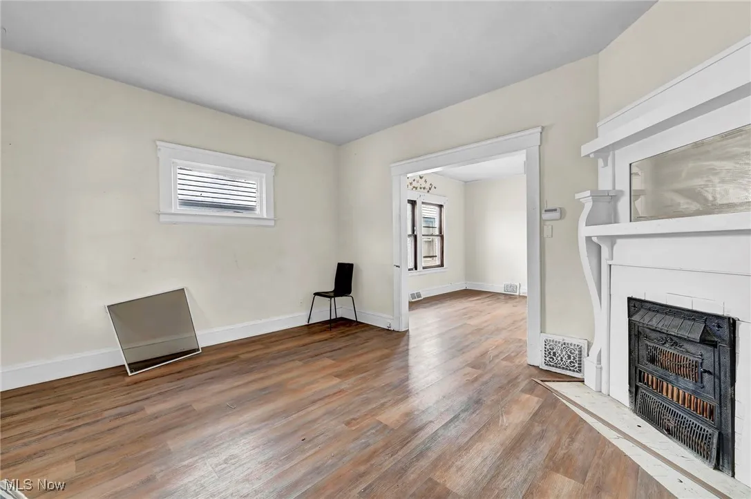 Unfurnished living room with wood finished floors and a fireplace with flush hearth