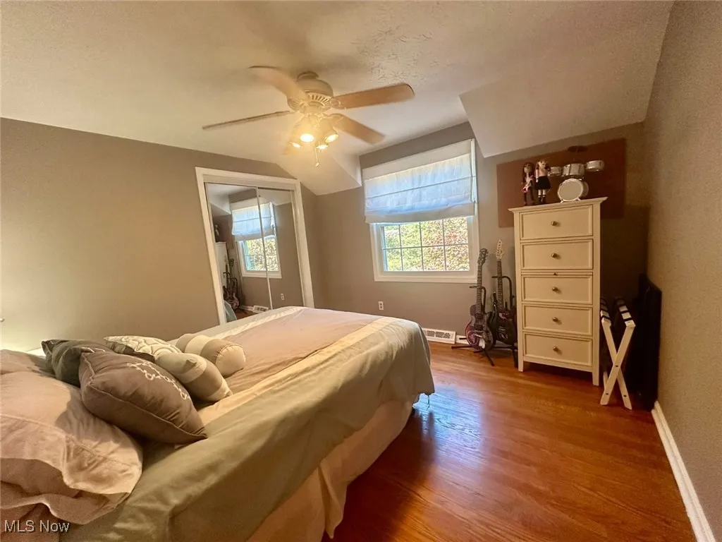Bedroom featuring light wood-style floors, a ceiling fan, a closet, and a textured ceiling