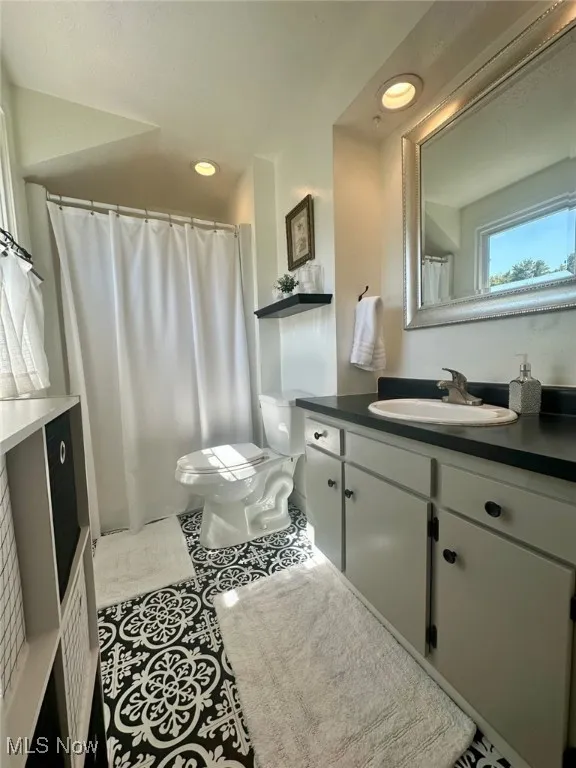 Full bathroom featuring vanity, light tile patterned floors, recessed lighting, and a shower with curtain