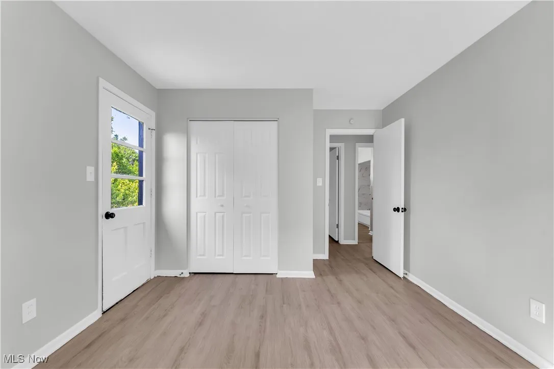 Unfurnished bedroom featuring light wood-type flooring and a closet