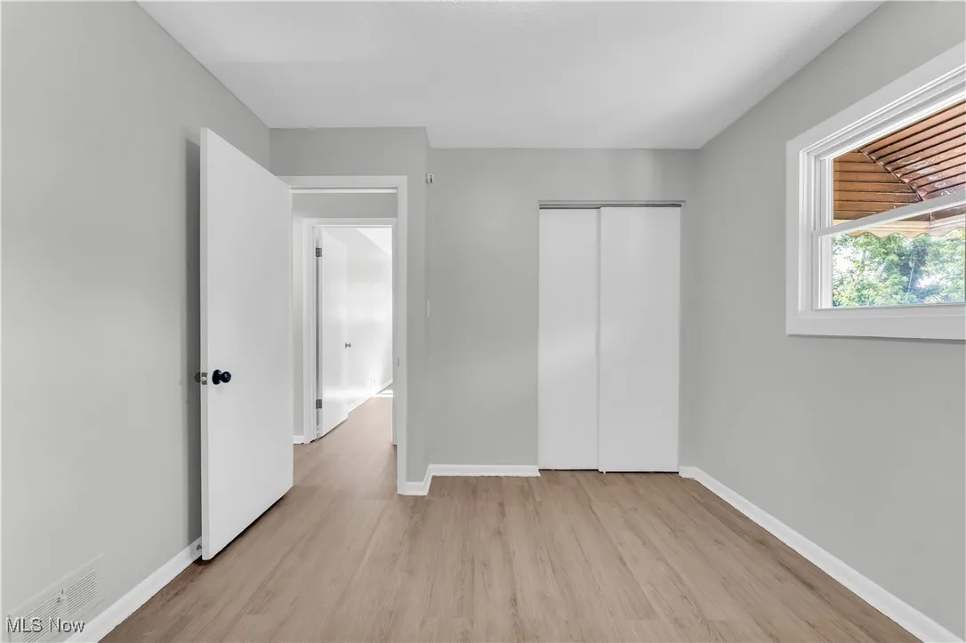 Unfurnished bedroom featuring light wood-type flooring and a closet