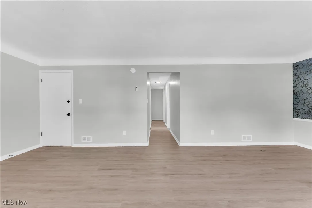 Empty room featuring light wood-type flooring and baseboards
