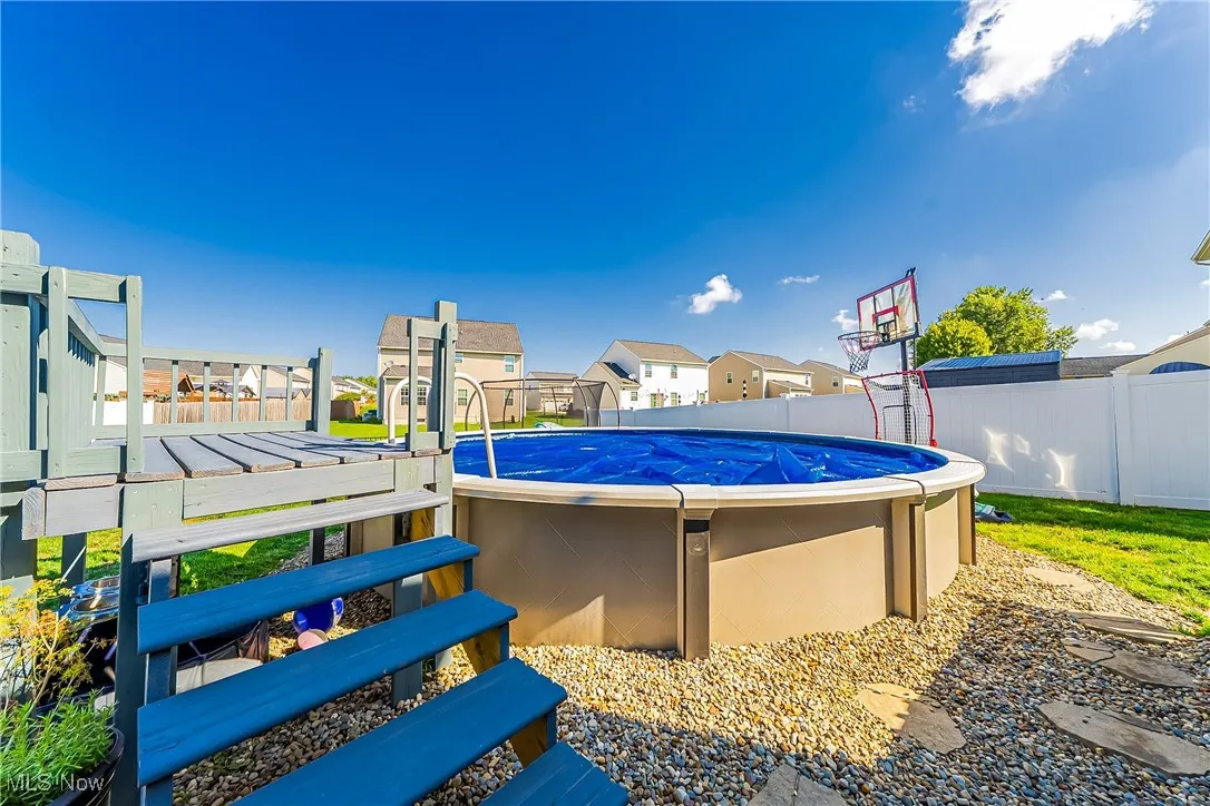 View of pool with a residential view and a fenced backyard