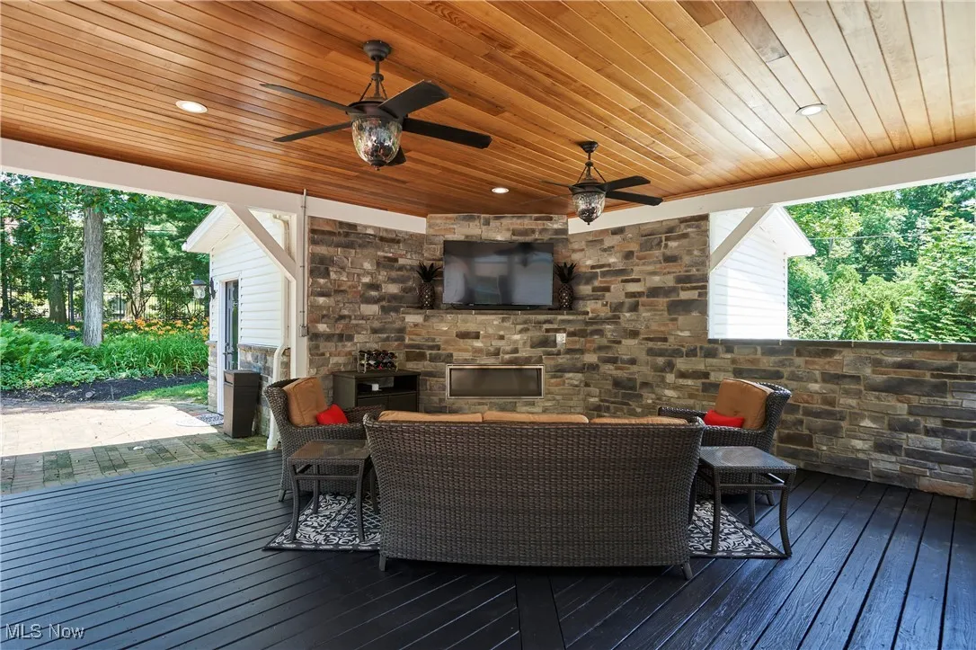 Wooden terrace with outdoor lounge area and ceiling fan