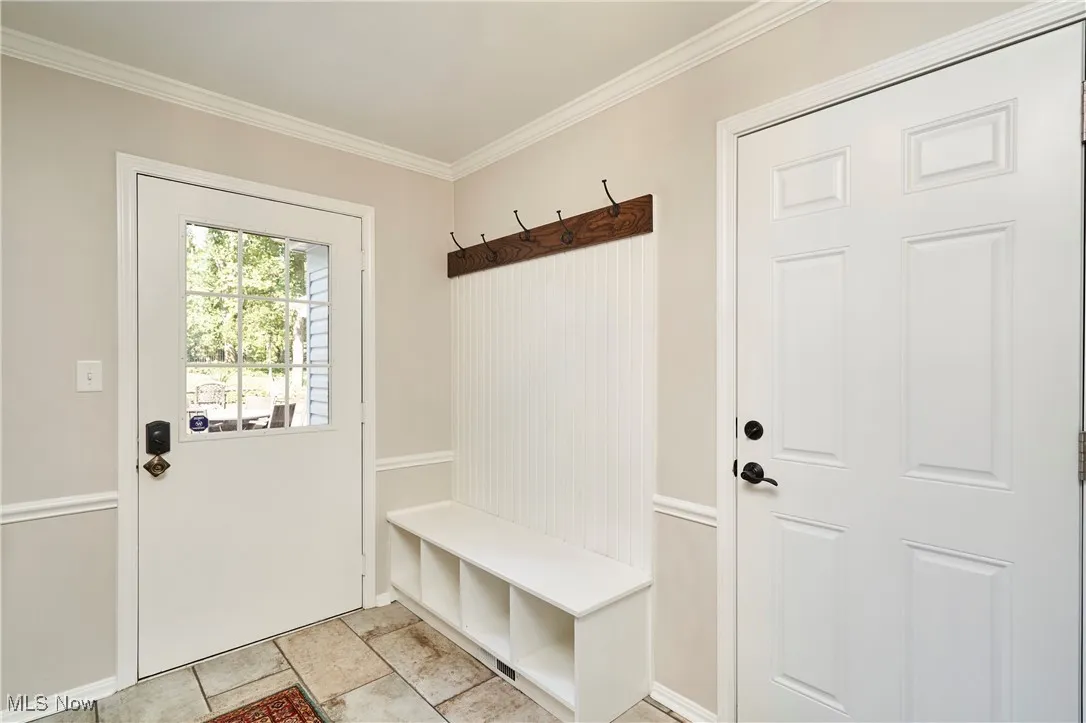Mudroom with crown molding and baseboards