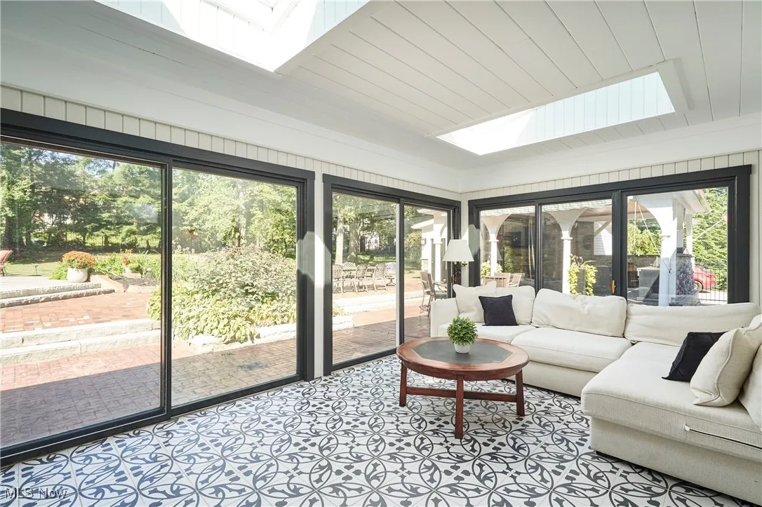 Sunroom featuring a skylight and wooden ceiling