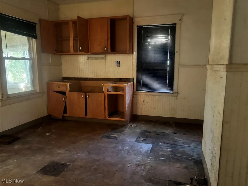 Kitchen with brown cabinets and wooden walls