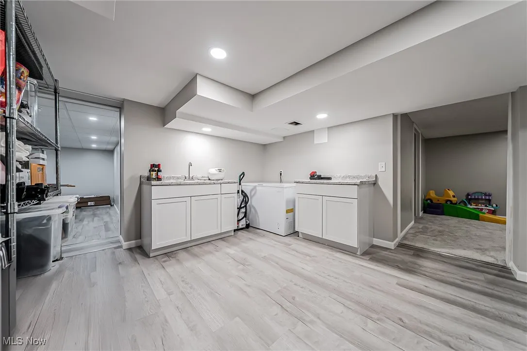 Washroom with light wood-style flooring and recessed lighting