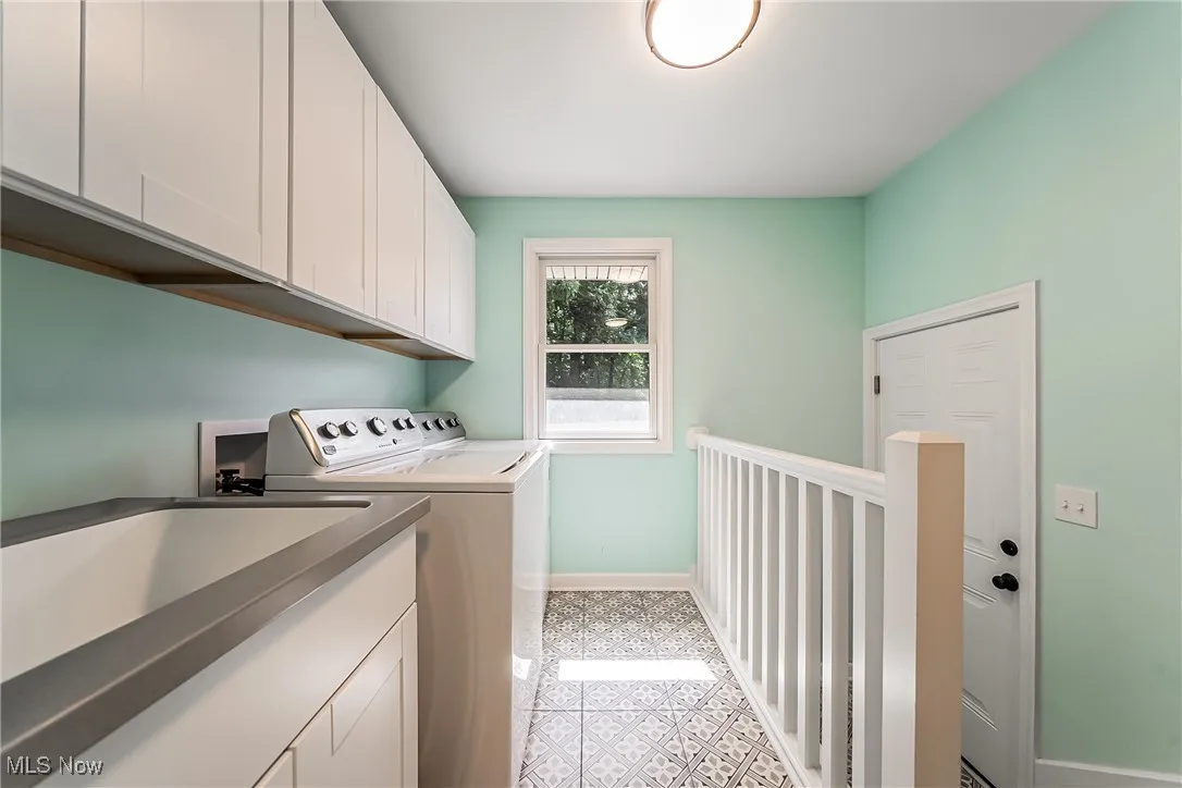 Washroom featuring cabinet space and separate washer and dryer