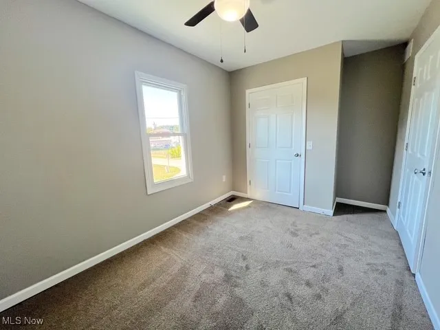 Unfurnished bedroom with carpet flooring and ceiling fan