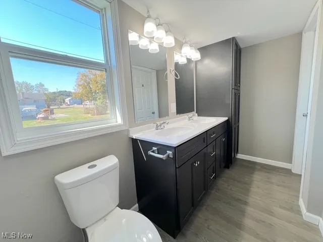 Bathroom with double vanity and light wood-style floors