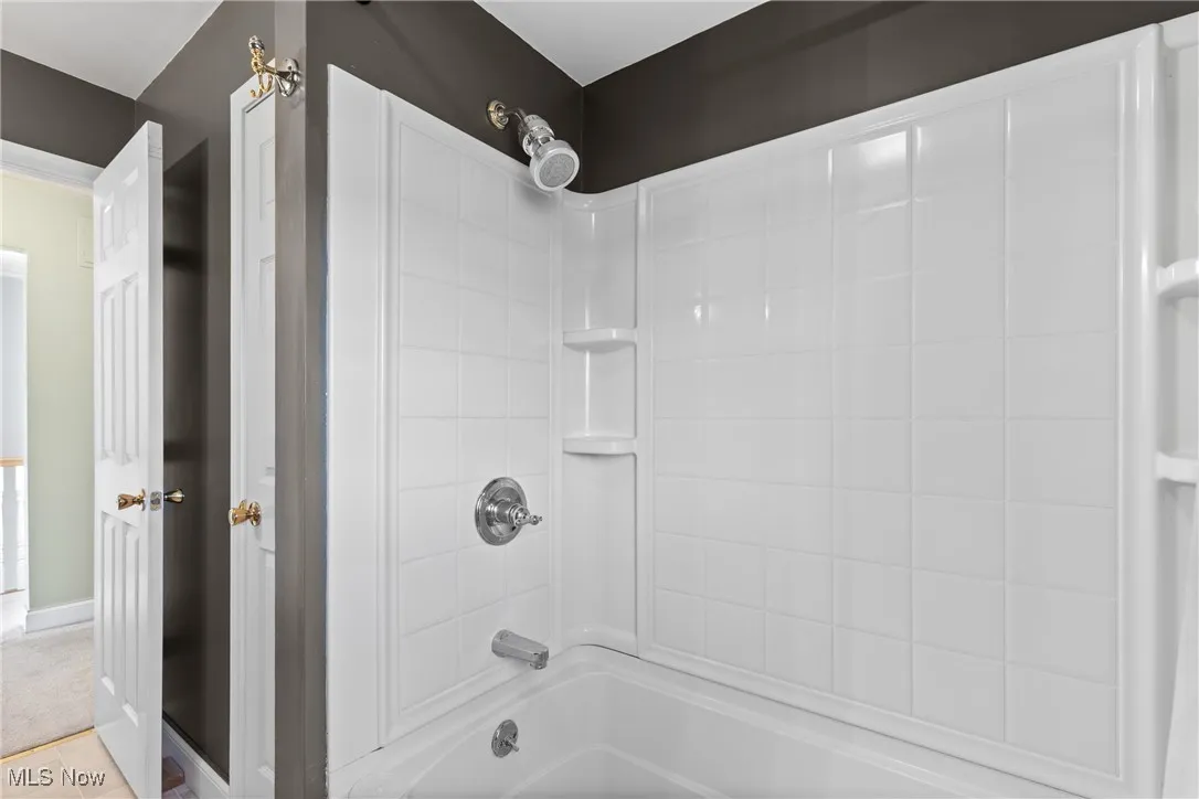Full bath featuring shower / tub combination and light tile patterned floors
