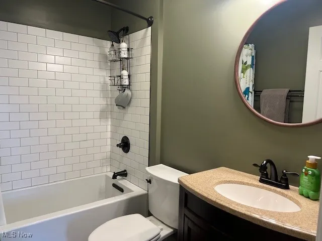 Bathroom with shower / tub combo with curtain and vanity