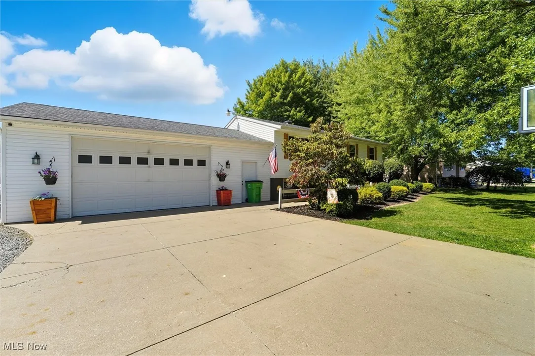 Split level home featuring concrete driveway, a garage, and a front yard