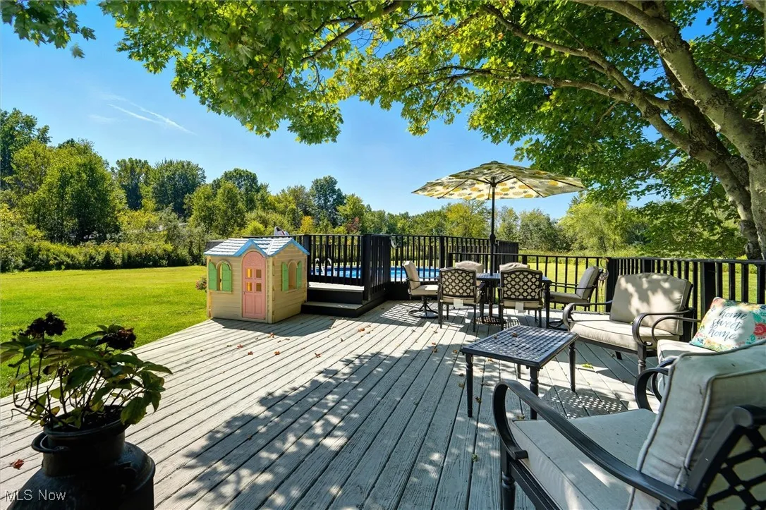 Deck featuring an outdoor hangout area, view of scattered trees, and a yard