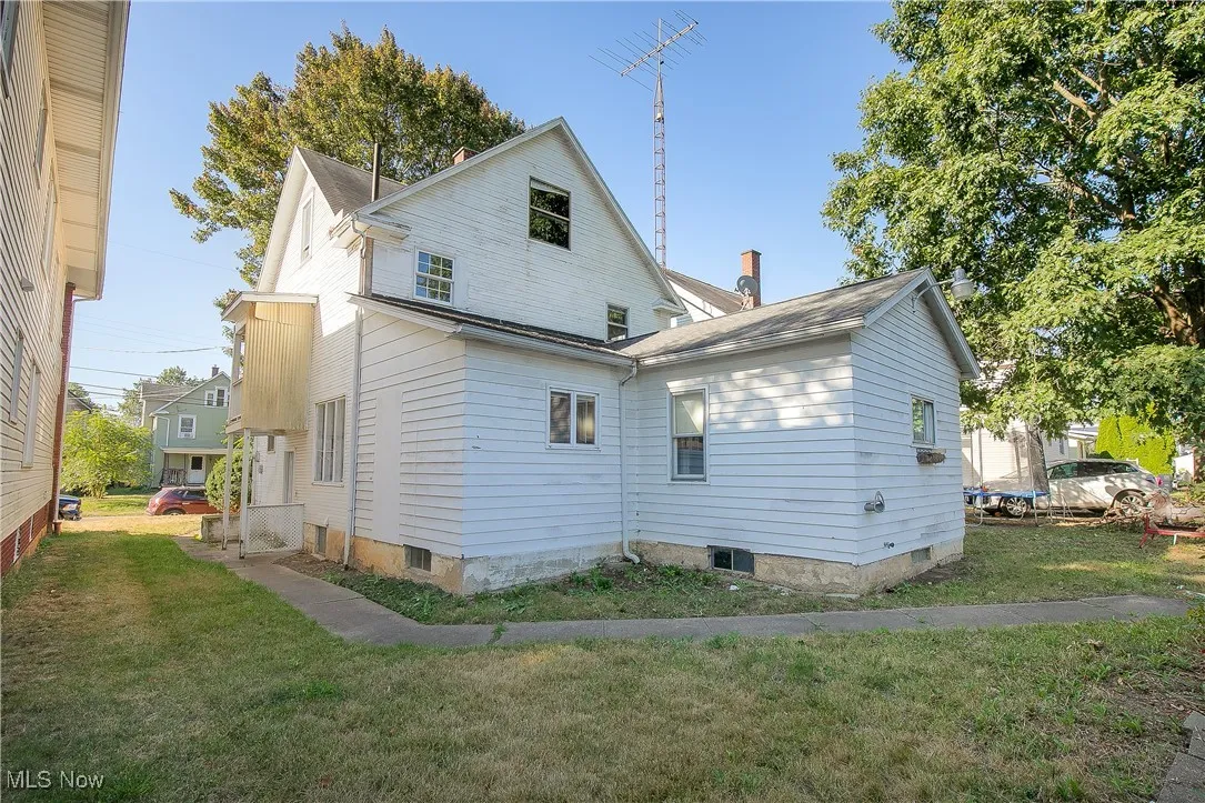 Back of property with a lawn and a chimney