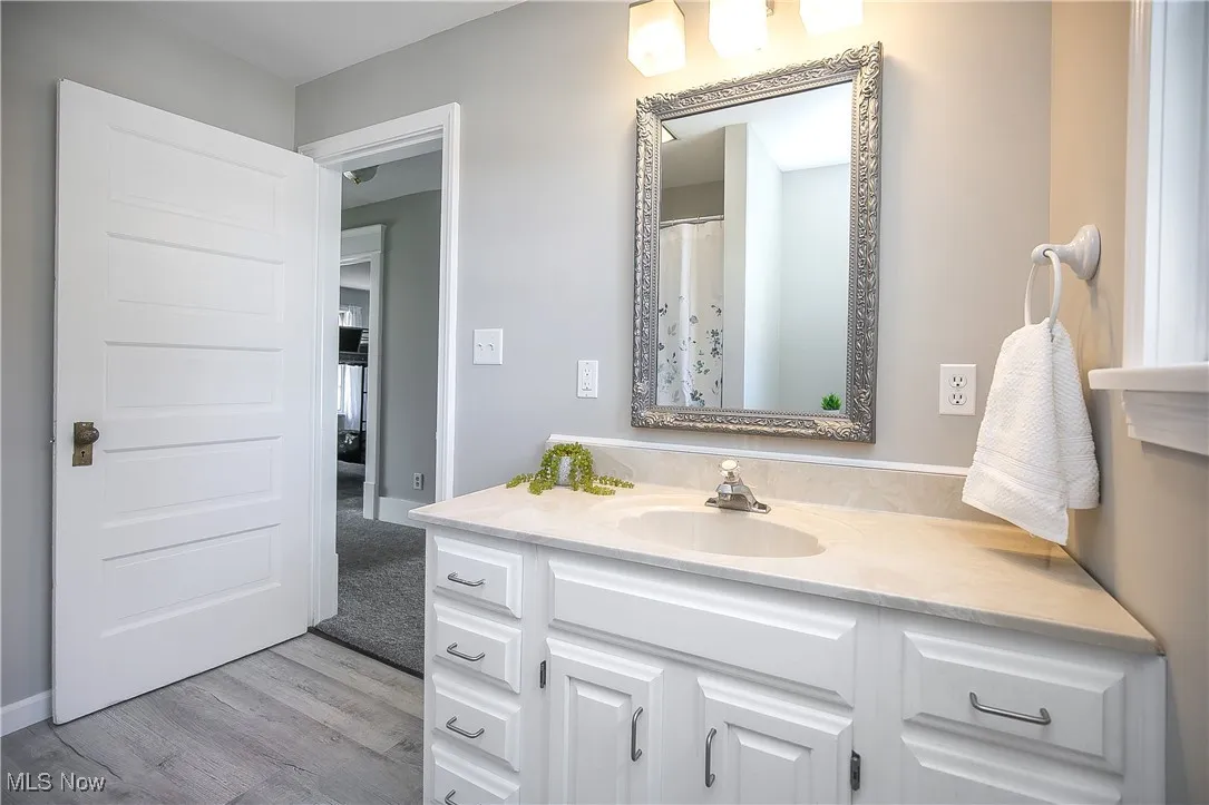 Full bath featuring vanity, light wood-style floors, and a shower with shower curtain